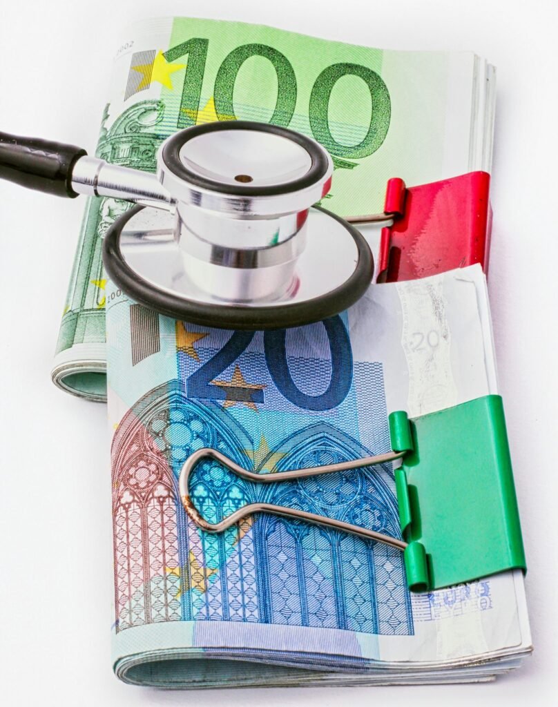 A stethoscope resting on a pile of money, representing the cost of medical care
